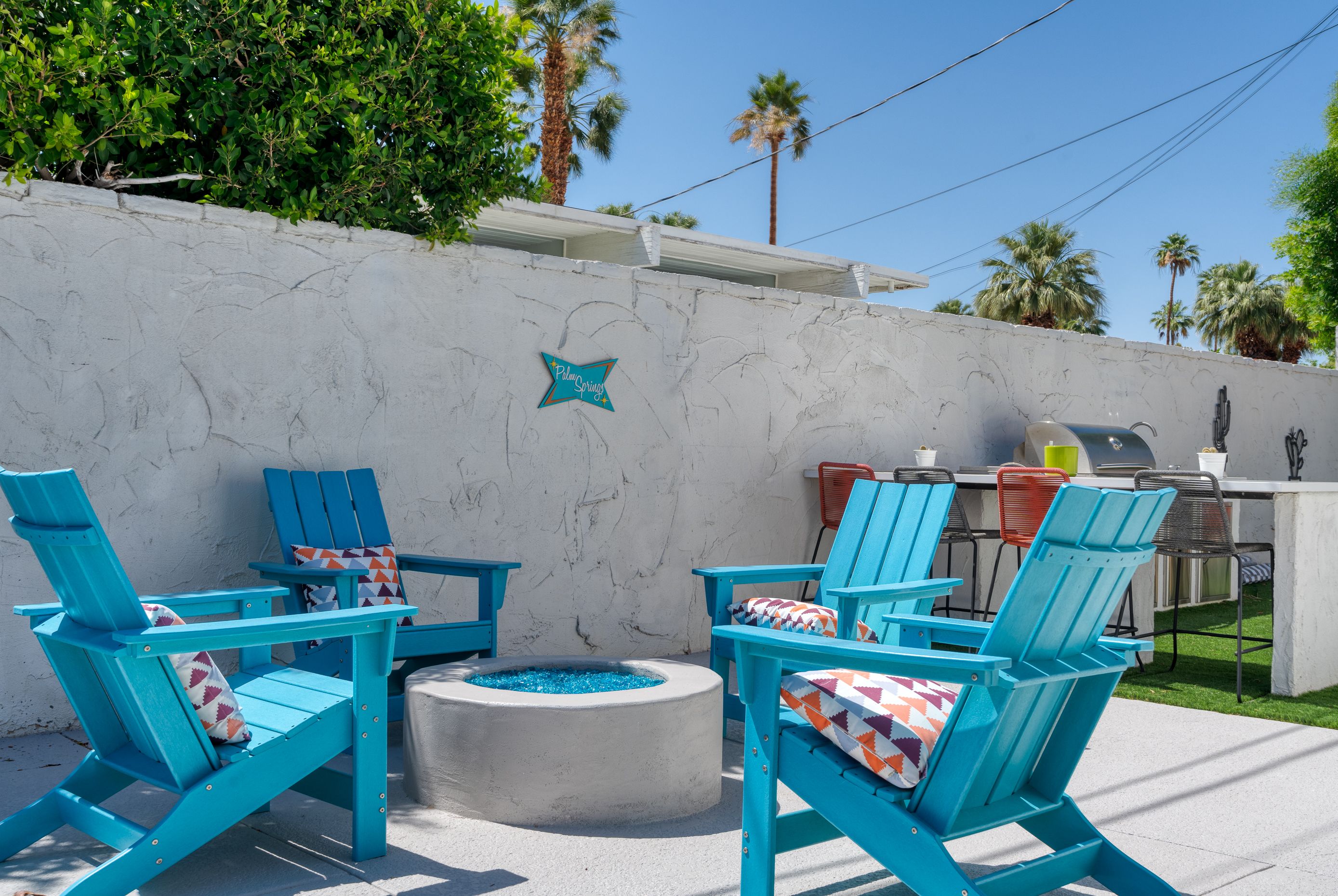 Turquoise chairs gathered around a fire pit in the private yard