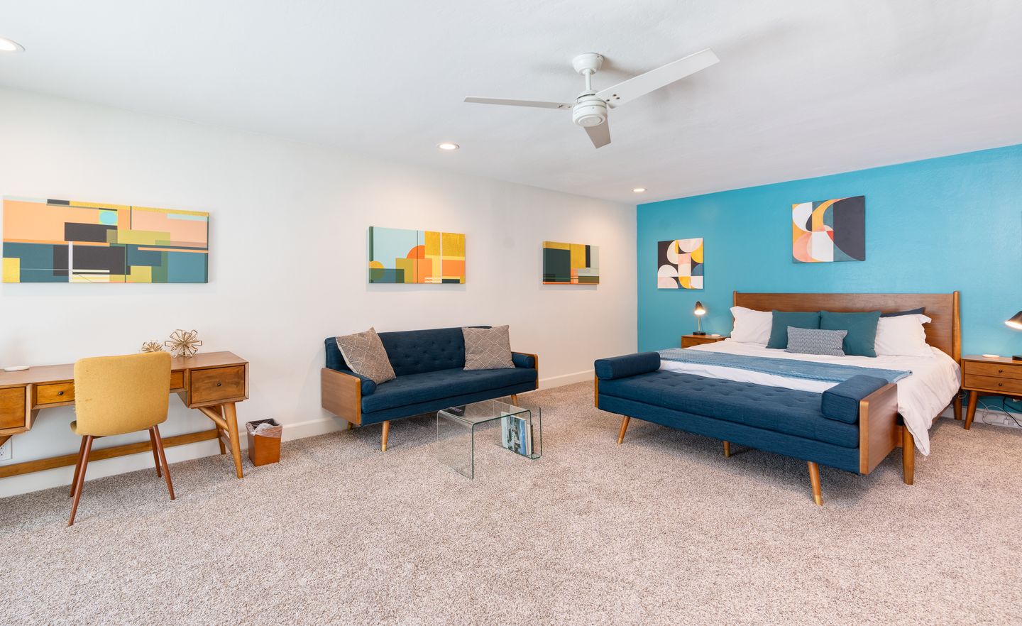 Wide view of the Aqua Bedroom king bed and blue sofa