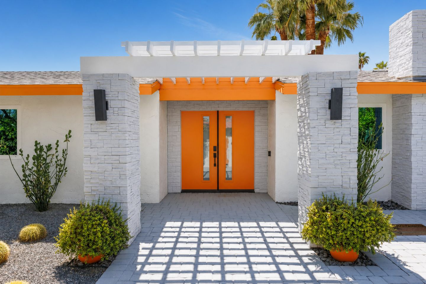 Front entry framed by desert landscaping and a geometric walkway