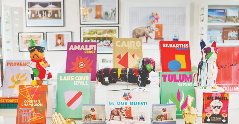 Colorful Assouline coffee-table books and painted animal sculptures arranged in a Just Fabulous display.
