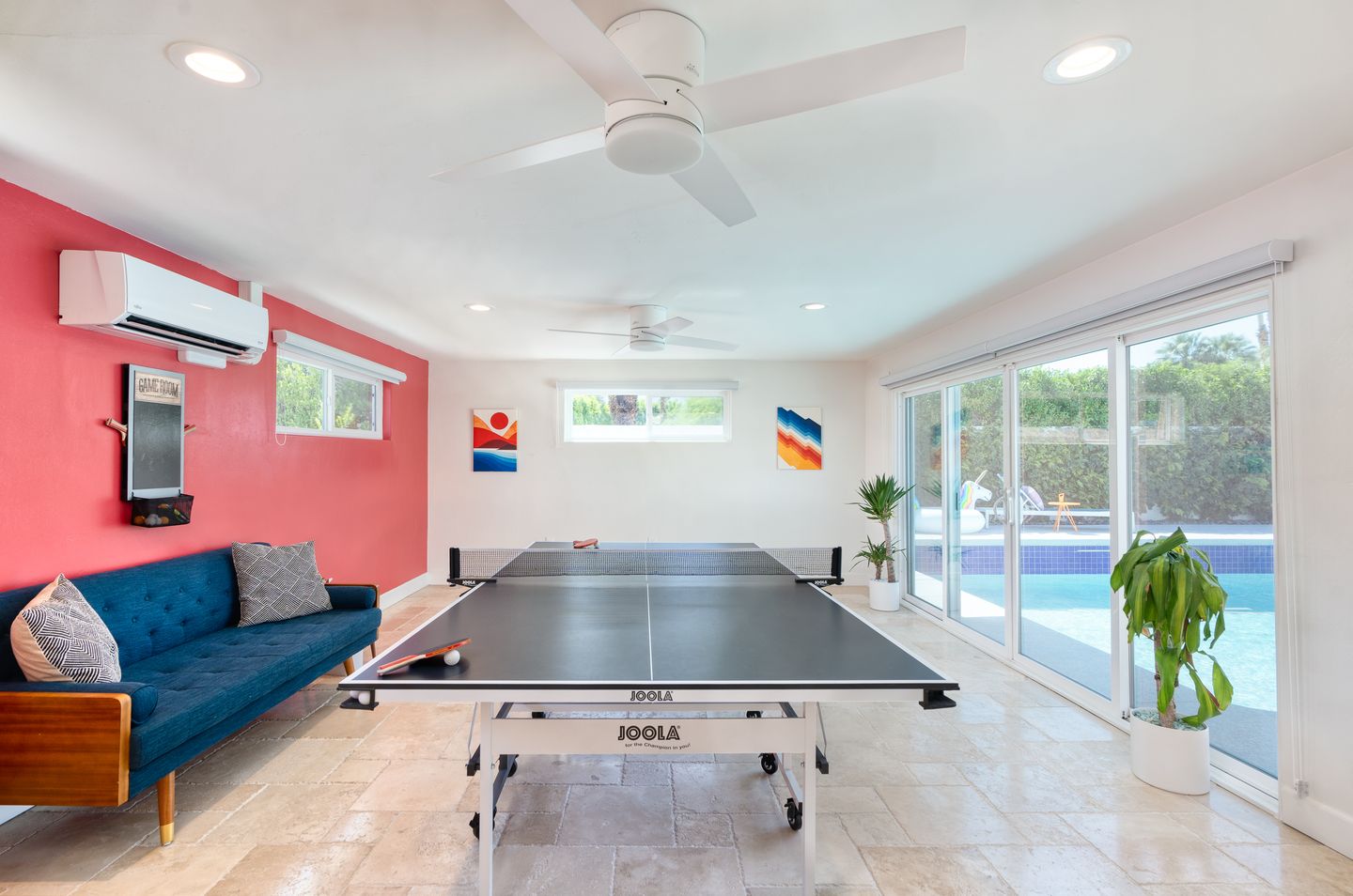 Sunlit Game Room with a ping-pong table and raspberry accent wall
