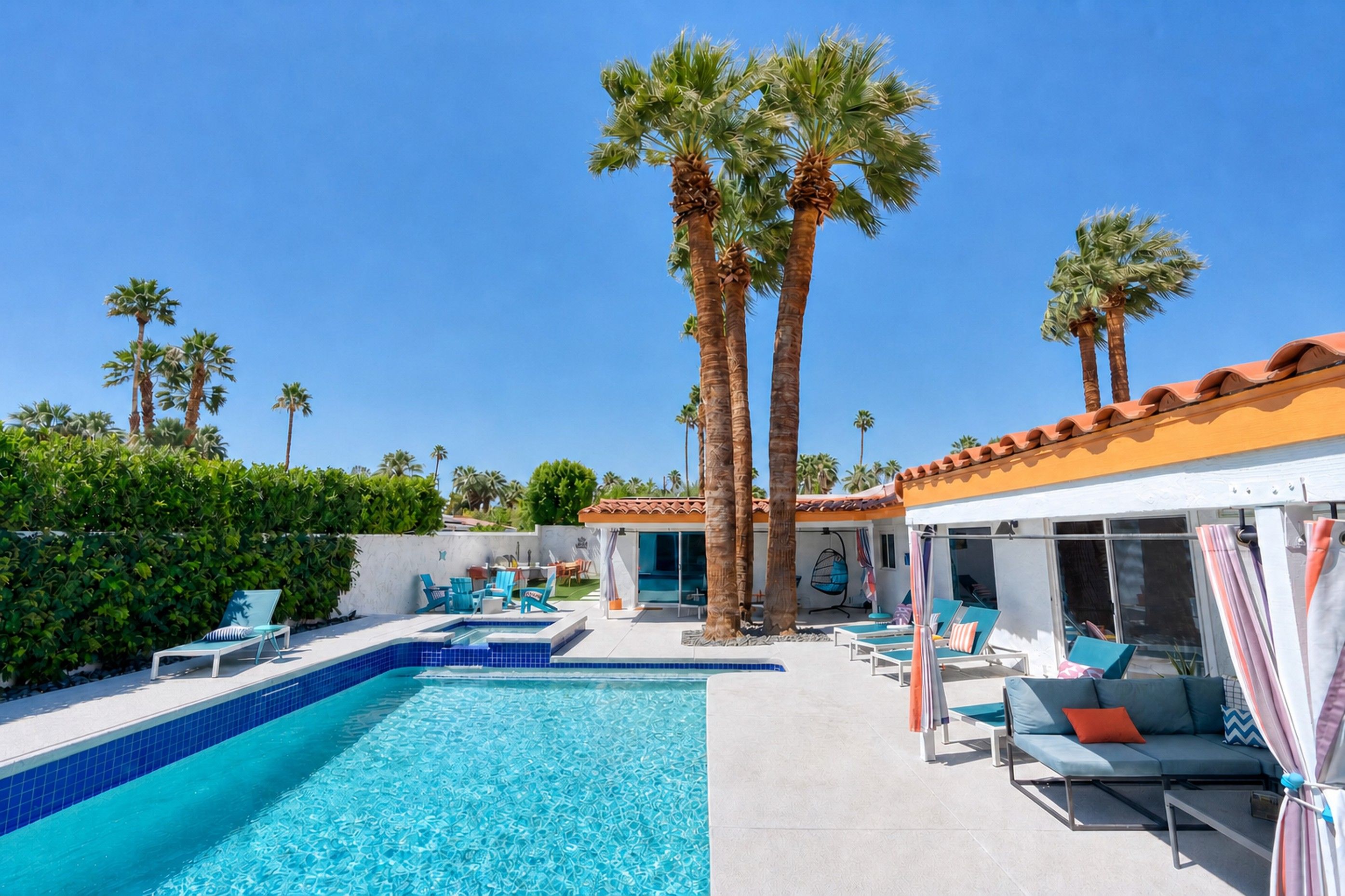 The Orchid House pool, spa, palms, and shaded lounge area on a sunny day