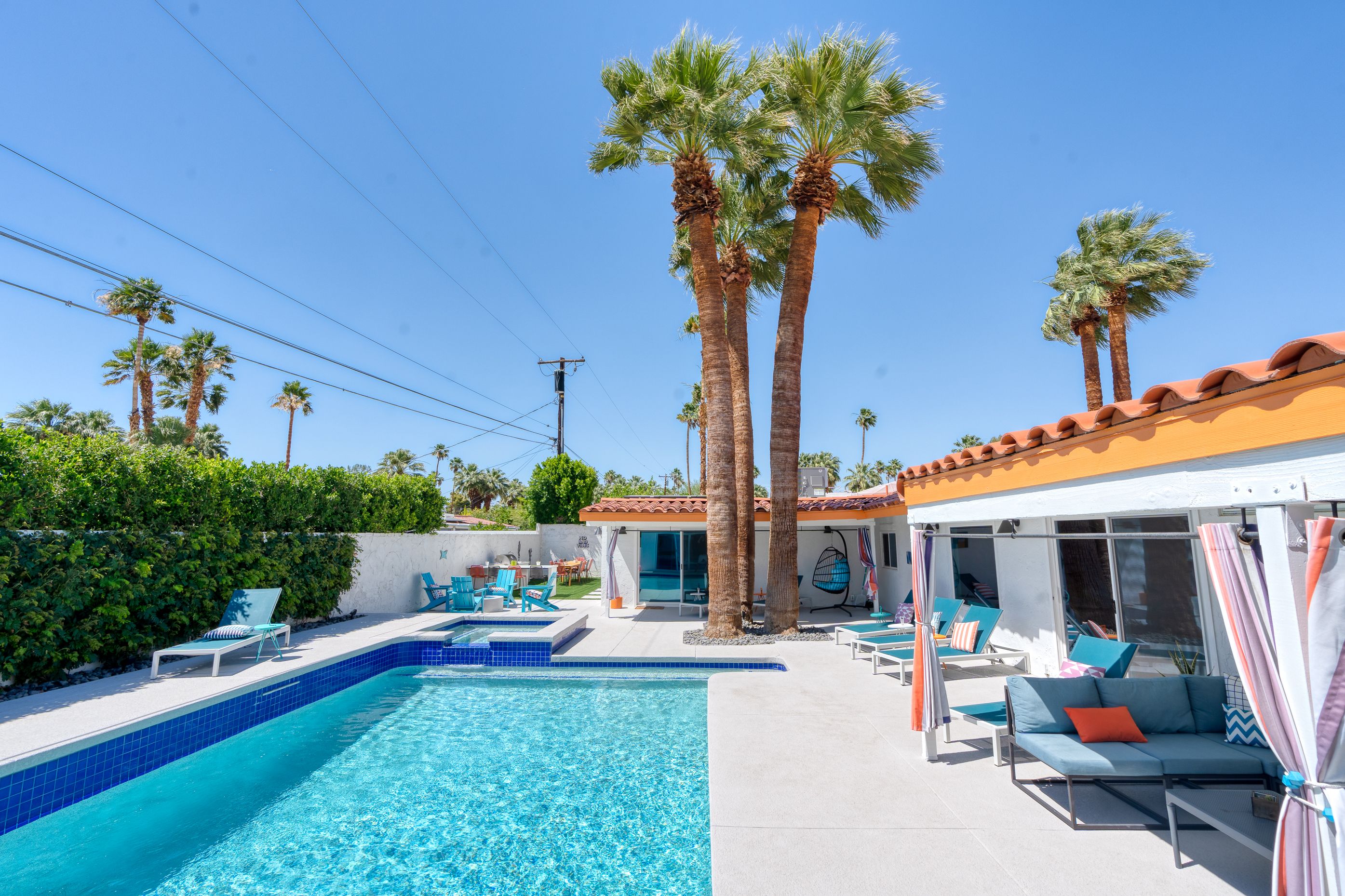 The Orchid House pool, spa, palms, and shaded lounge area on a sunny day